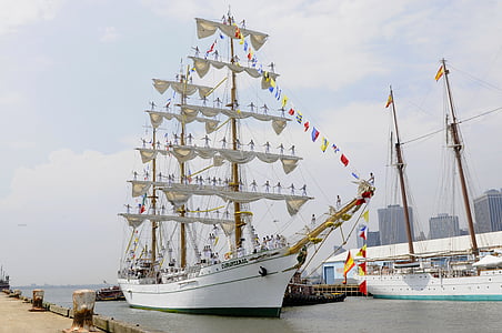 white sail boat docked beside port thumbnail