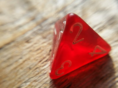 close-up photography of triangle red dice on brown wooden surface thumbnail