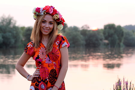 woman wearing flower headdress near body of water thumbnail