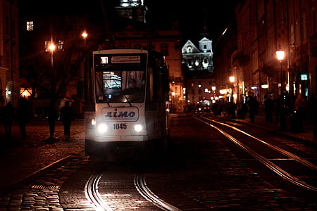 white train on road during night-time thumbnail