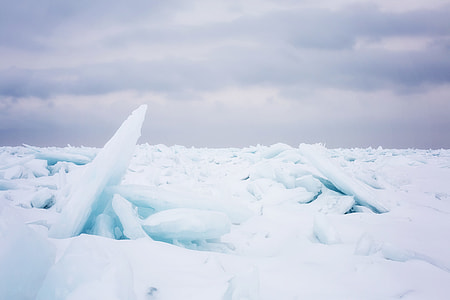 iceberg covered body of water during day thumbnail