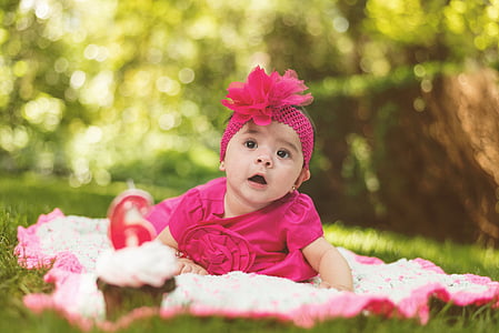 selective focus photo of baby sitting on white mat thumbnail