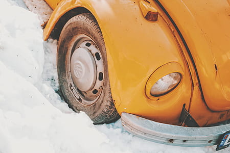 orange Volkswagen Beetle coupe on snow field thumbnail