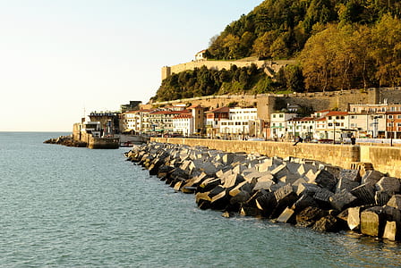 long-angle photography of sea near village by day thumbnail
