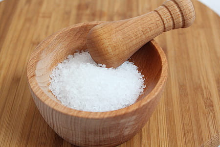 white salt on brown wooden mortar and pestle thumbnail