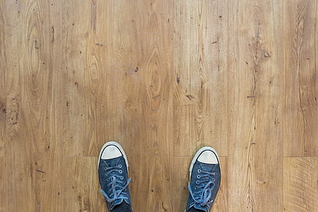 gray-and-white canvas low-top sneakers on brown wooden floor thumbnail