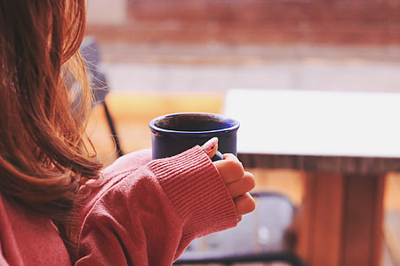 woman in pink jacket holding mug thumbnail