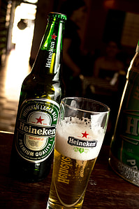 Heinneken glass bottle beside cup thumbnail