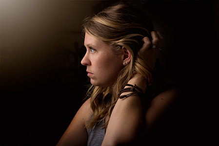 low light photography of woman holding her hair thumbnail