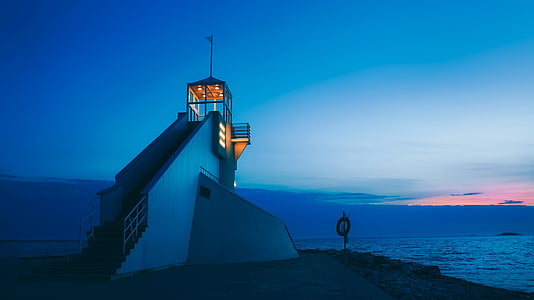 lighted guardhouse near sea at night thumbnail