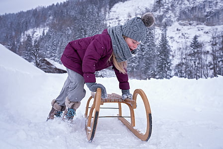 girl holding brown wooden sled thumbnail