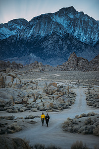 Two person walking on pathway surrounded by rocks thumbnail