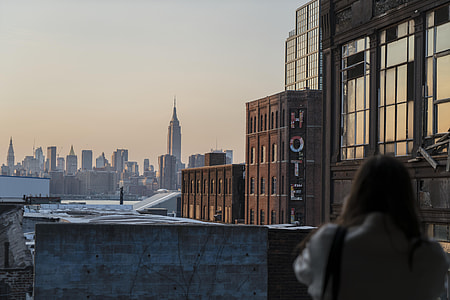 woman near brown concrete Hotel building thumbnail