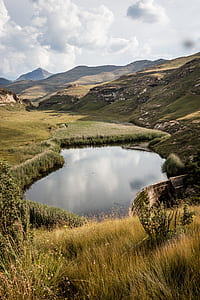 landscape photography of swamp surrounded with mountains thumbnail