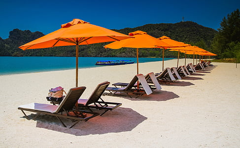 row lounger chairs and parasols on shore at daytime thumbnail