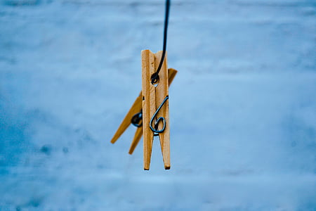 two brown wooden cloth pegs hanged on tie thumbnail