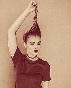 woman holding her hair while leaning on wall thumbnail
