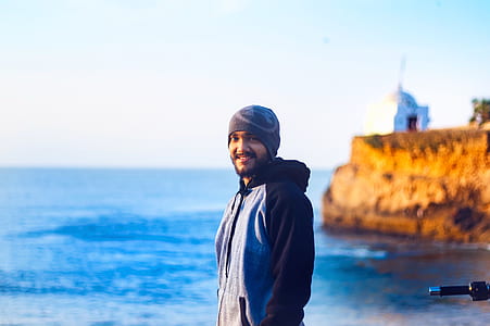 Man Wearing Gray Knit Cap and Pullover Hoodie Beside Beach thumbnail