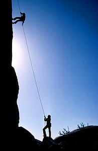 man climbing using rope near man on the ground looking up thumbnail