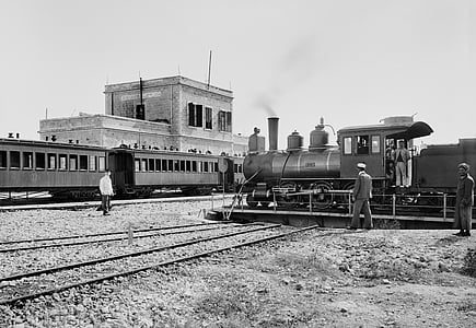 grayscale photo of man standing near train thumbnail