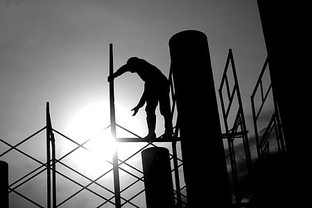 silhouette photography of man standing on scaffold thumbnail