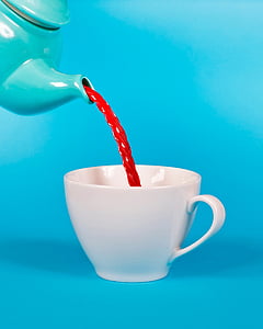 teapot pouring red beverage on mug thumbnail