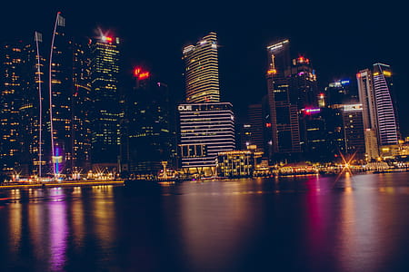Buildings Near Body Of Water During Night Time thumbnail