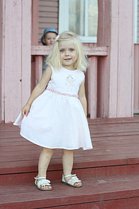 girl wearing white dress standing on wooden ladder thumbnail