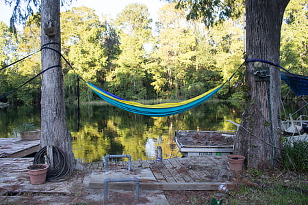 empty blue and yellow hammock near body of water thumbnail