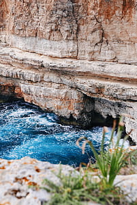 body of water splashing on rock cliff thumbnail