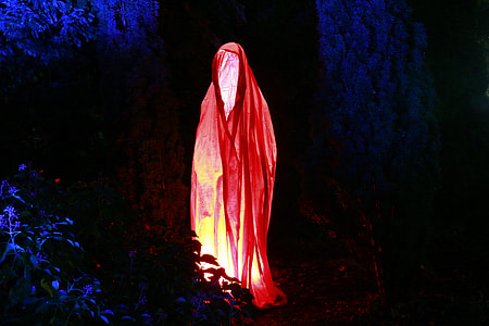 person wearing red shawl surrounded with leaves thumbnail