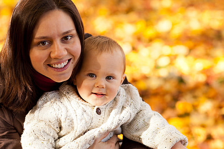 woman holding her baby wearing white long sleeve shirt thumbnail