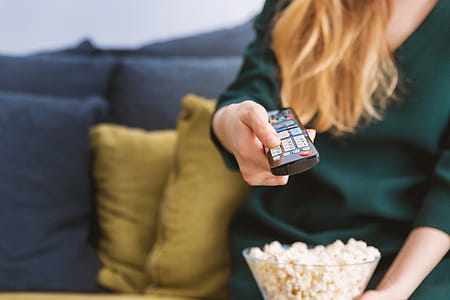 Young girl with TV remote and a popcorn at home thumbnail