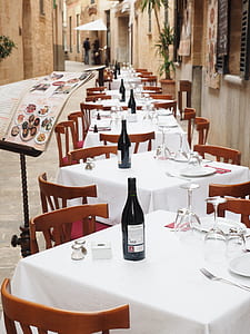 lined tables and chairs beside house during daytime thumbnail