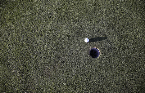 golf ball near golf hole during day time thumbnail