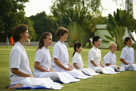 people sitting on grass while meditating thumbnail