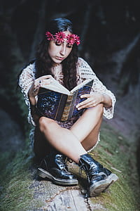 woman sitting on branch while reading book thumbnail