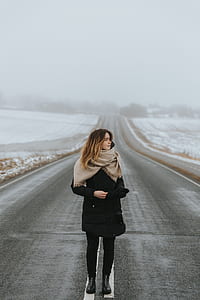 woman wearing black coat standing on gray concrete road thumbnail