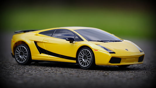 yellow Lamborghini Gallardo coupe scale model on gray concrete surface thumbnail