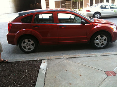 red 5-door hatchback parked near house thumbnail