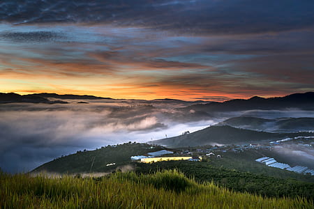 photography of mountains under orange and gray cloudy sky thumbnail