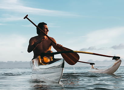 Man Riding on Boat Holding Brown Paddle thumbnail