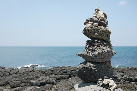 balance stone near body of water thumbnail