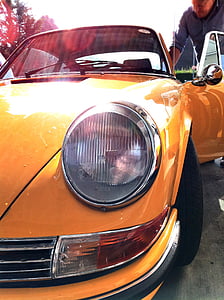 man getting inside vintage yellow Porsche coupe thumbnail
