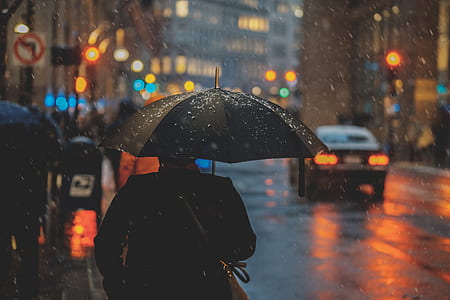 person holding umbrella during rainy day thumbnail