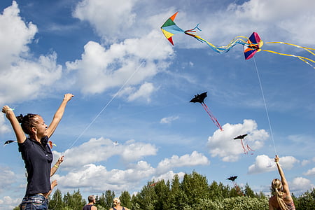 woman holding playing paper kite under cloudy blue sky during daytime thumbnail