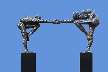 two human holding hand statue under clear sky thumbnail