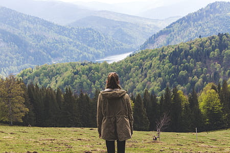 Photo of Woman Wearing Jacket Standing Near Forest Trees thumbnail