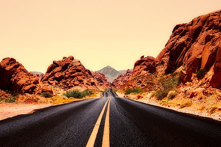 black asphalt road beside brown rock mountain thumbnail