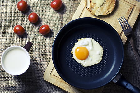 sunny side up on frying pan near stainless steel fork thumbnail